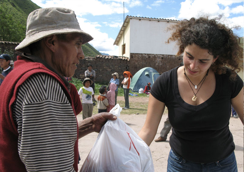 Danièle Turkier hands over a bag with food to the people in need