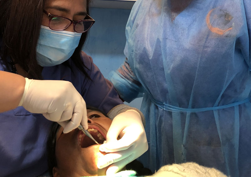 Nuestra dentista Dra. Flor Salvador está curando a un paciente en el Centro Médico